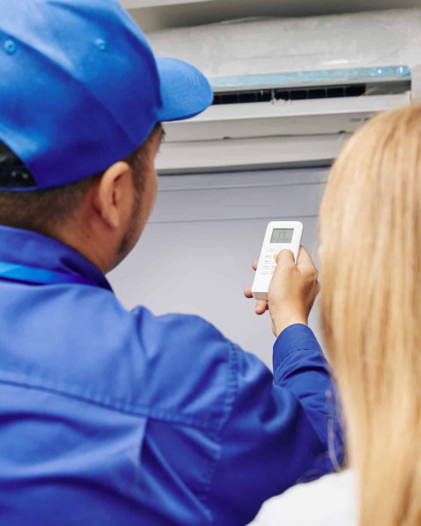 Person adjusting air conditioner remotely.